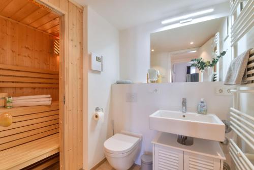 a bathroom with a white sink and a toilet at Ferienwohnung SPA Penthouse Meerlust Baabe in Baabe