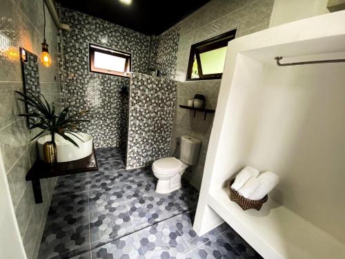 a bathroom with a toilet and a potted plant at Sweet Room by Maliblue Khanom in Ban Phang Phrao