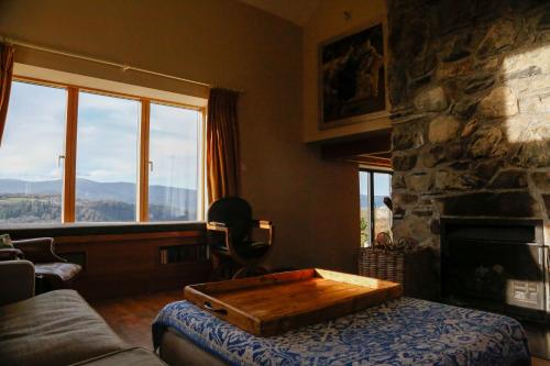 a living room with a couch and a stone fireplace at Ty Uchaf in Colwyn Bay