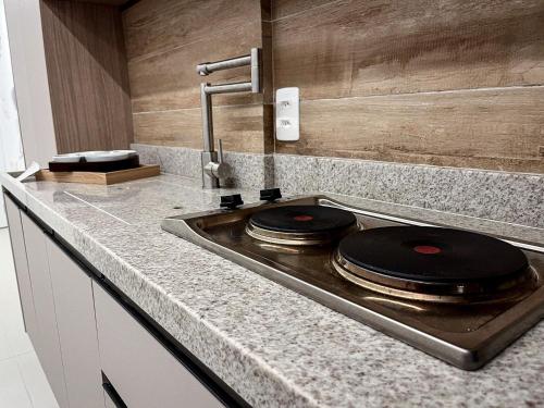 a kitchen with a stove with two plates on it at Skylux By Cris Borriello Luxury in Rio de Janeiro