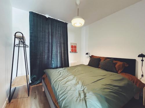a bedroom with a bed with a tripod next to a window at Suite Jaurès in Rethel