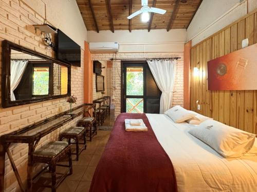 a bedroom with a large bed and some chairs at Pousada da Chacara in Nova Petrópolis