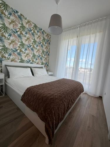 a bedroom with a large bed with a large window at MH Lippolis in Bari
