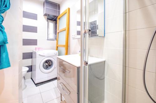 a bathroom with a washing machine and a washer at Les apparts du TRECH in Tulle