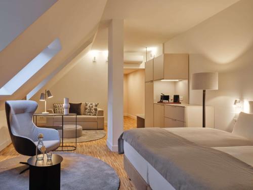 a bedroom with a bed and a chair in a room at Classik Hotel Hackescher Markt - Self Check In in Berlin