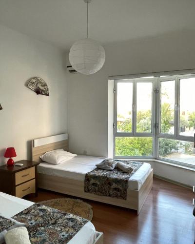 a bedroom with two beds and a large window at Rix Palm Apartments in Kyrenia