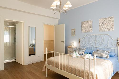 a bedroom with a bed with a blue headboard at Dolce Conero Guest House in Camerano