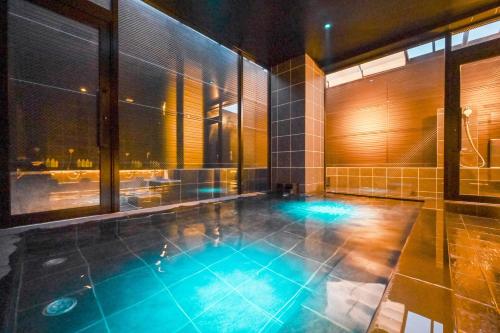 an indoor pool in a building with a view of the city at Ureshino Onsen Yadoya Uchiroji in Ureshino