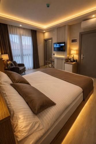 a large bed in a hotel room with a television at Airport Corner Hotel in Trabzon