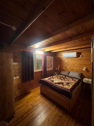a bedroom with a bed in a wooden cabin at בקתת העץ של מירה ואמיר in Beit Hillel