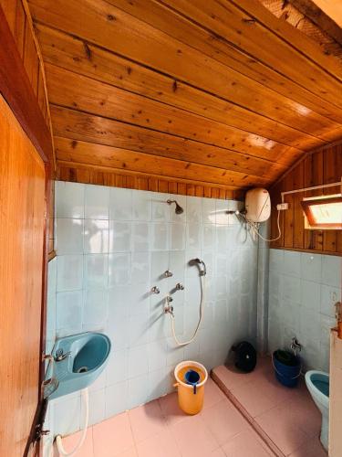 a bathroom with a shower and a sink and a toilet at Red Panda Ecohut in Lava