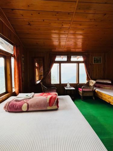 a bedroom with two beds in a room with windows at Red Panda Ecohut in Lava