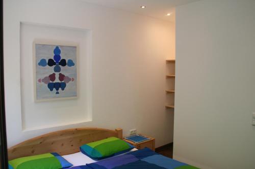 a bedroom with a bed and a painting on the wall at Hupfmühle Pension in St. Wolfgang