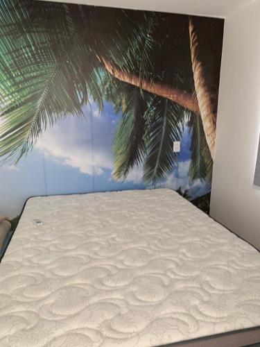 a bed with a painting on the top of it at Paraiso dos coqueiros - Guarajuba - Bahia -Linha verde in Camaçari
