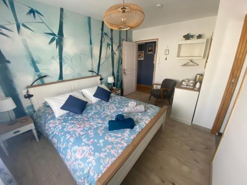 a bedroom with a bed with a blue bedspread at La Note Bleue - Chambres d'hôtes in Échillais