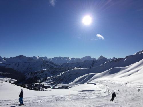 two people are skiing on a snow covered mountain at Gästehaus Manuela Puchmayr in Mellau