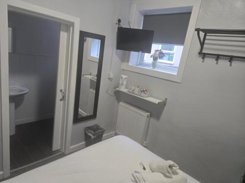 a bathroom with a bed and a sink and a mirror at Peek-a-Booze - Budget Hotel - Adults Only in Blackpool
