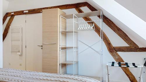 a glass bookcase in a room with a bed at Escapade à Blainville-Crevon in Blainville-Crevon