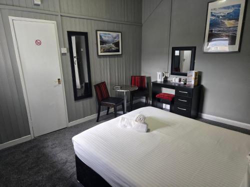 a hotel room with a bed and a desk at Peek-a-Booze - Budget Hotel - Adults Only in Blackpool