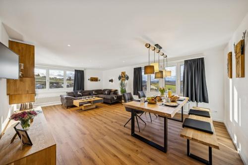 a living room with a table and a couch at Suite4you Erlen l Privater Indoorpool ganzjährig beheizt & Sauna l 10min zum Bodensee, Parkplatz & WLAN in Erlen