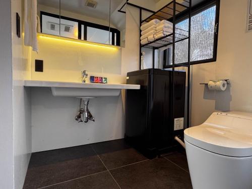 a bathroom with a toilet and a sink at Ryukyu Garden in Nanjo