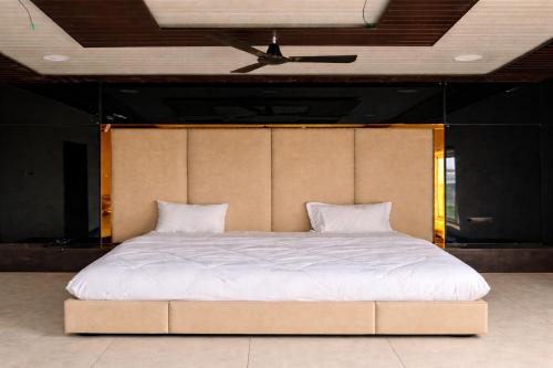 a large bed in a room with a ceiling at The Golden Wings Hotel in Dewās