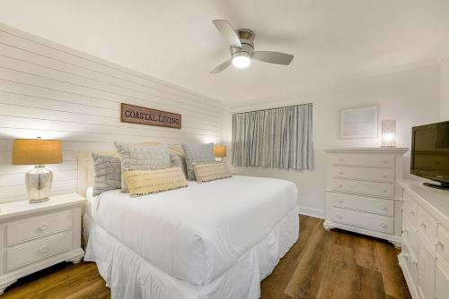a white bedroom with a bed and a television at Dune Villas 2A - Gulf Front Vacation Condominium with Shared Pool in Santa Rosa Beach