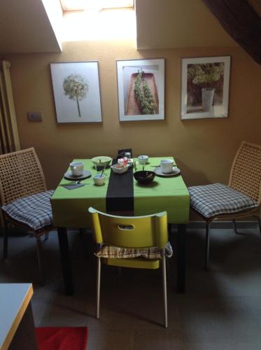a dining room with a green table and chairs at Eco Rooms&Breakfast Tirano in Tirano