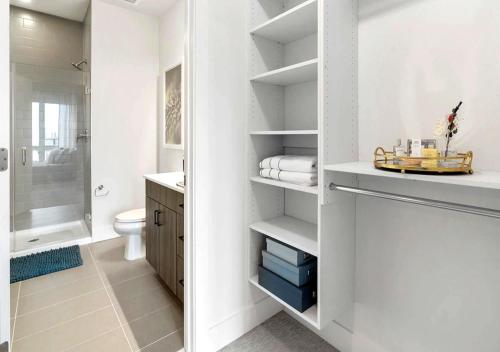 a white bathroom with a toilet and a sink at SE Furnished Apartment in Atlanta