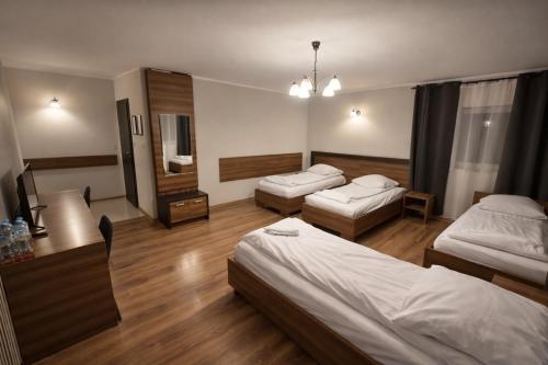 a hotel room with two beds and a mirror at Hotel Bukowiec in Legionowo
