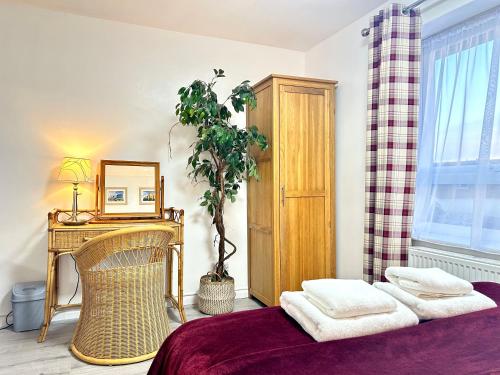 a bedroom with a bed and a table and a plant at Victory Gate 3 double bed House in Old Portsmouth Parking Pets in Portsmouth