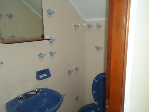 y baño con lavabo azul y aseo. en Complejo Punta Villa en Villa Gesell