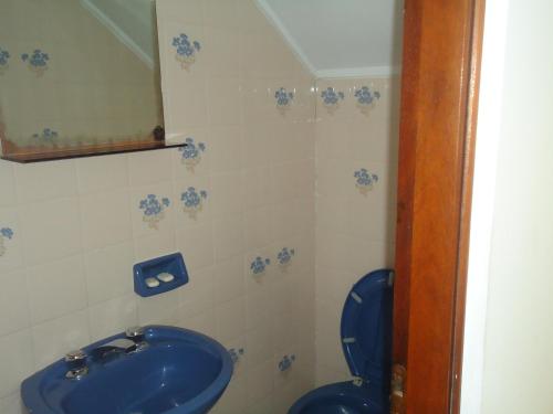 y baño con aseo azul y aseo. en Complejo Punta Villa en Villa Gesell