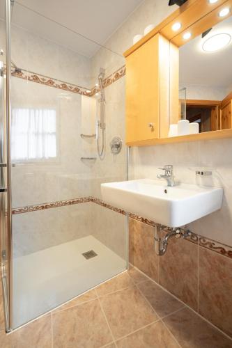 a bathroom with a sink and a shower at Apartments Mauriz in Selva di Val Gardena