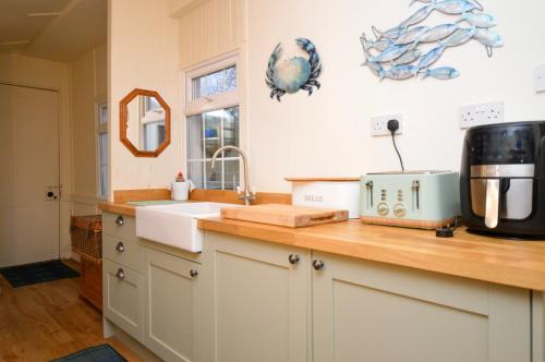 a kitchen with a sink and a microwave on a counter at Aldersyde in Tighnabruaich