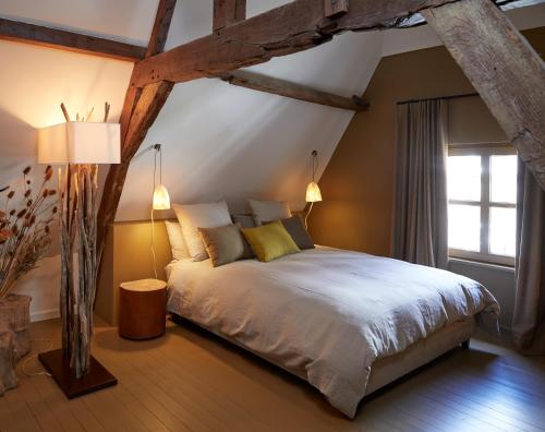 a bedroom with a large bed in the attic at Le Nid Fleuri - Séjour familial à Tournai in Tournai