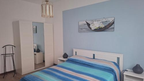 a bedroom with a bed and a picture of a boat at Cologno Centro Apartment in Cologno Monzese