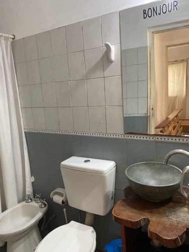 a bathroom with a white toilet and a sink at Casa con quincho en el Volcán in El Volcán