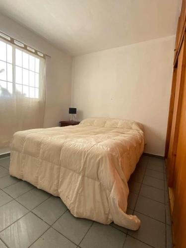 a bedroom with a large bed in a room with a window at Casa con quincho en el Volcán in El Volcán