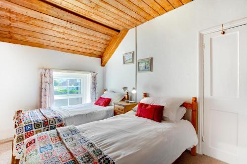 two beds in a bedroom with a wooden ceiling at 3 Bed in Gower oc-hh150 in Llangennith