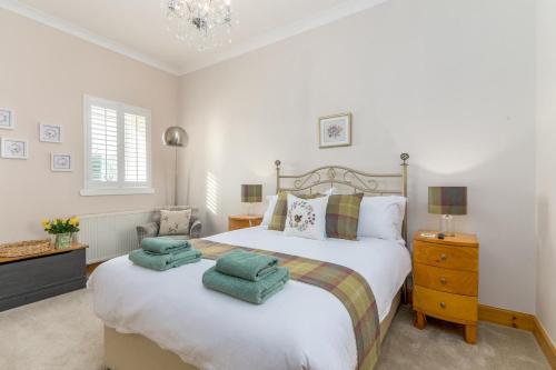 a bedroom with a large bed with green towels on it at 2 Bed in Rosyth oc-r30512 in Rosyth