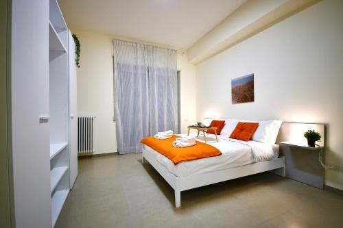 a bedroom with a bed with an orange blanket at Ètoile Palace Gravina in Gravina in Puglia