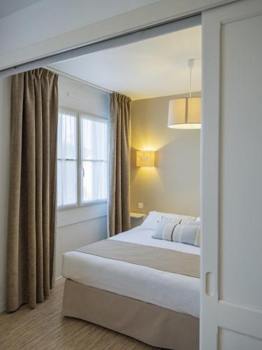 a bedroom with a large bed and a window at Hotel Autre Mer in Noirmoutier-en-l'lle