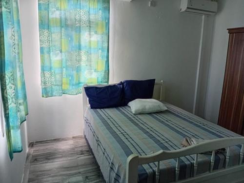 a bedroom with a bed with blue pillows at Quiet corner ideal for holidays in Centre de Flacq