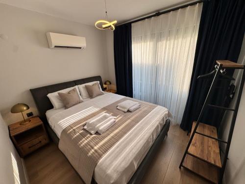 a bedroom with a bed with two towels on it at Stylish Lounge Apartment with Pool & Views in Fethiye