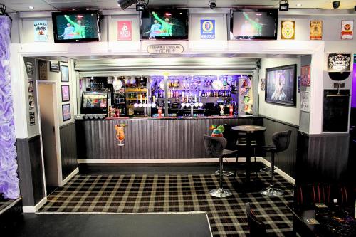 a bar with two stools in front of it at Peek-a-Booze - Budget Hotel - Adults Only in Blackpool