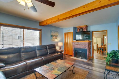 a living room with a leather couch and a fireplace at Old Ocean Beach Apt by Pier and Palace Playland in Old Orchard Beach