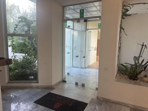 un corridoio con una porta a vetri che conduce a una doccia di Rodon Hotel a Chania