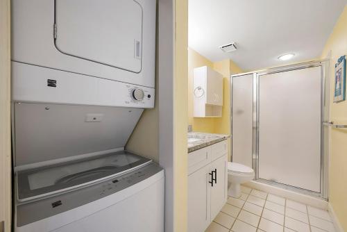 a small bathroom with a sink and a shower at Pelican Beach 1216 - Ocean Front Condo with Shared Pool & Beach Access in Destin