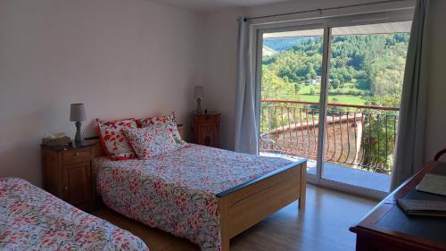 una camera da letto con due letti e un balcone con vista di Au Gite des Champs a Lamure-sur-Azergues